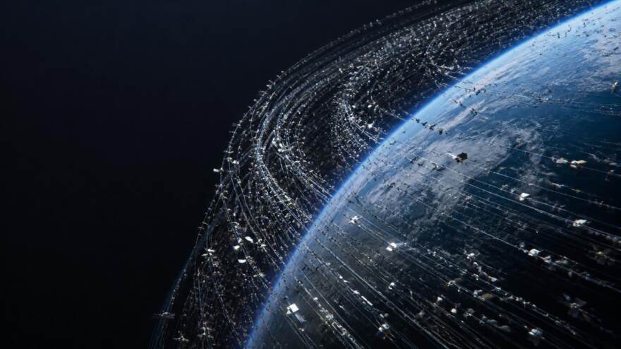地球の周囲を取り巻く低軌道に、無数の小さな衛星が層をなして密集している俯瞰イメージ。宇宙空間の「広さ」ではなく「詰まり具合」を印象づける構図で、記事全体のテーマを先取りする。